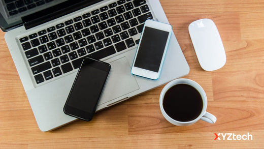 How to keep a phone battery healthy. 2 smartphones, one laptop, a wireless mouse, and a cup of coffee on a table. 